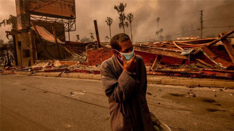 Ein Mann geht an einem vom „Eaton Fire“ verwüsteten Geschäft vorbei.