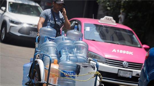 Ein Mann geht mit leeren Wasserkanistern durch eine Straße in Mexiko-Stadt. In 27 der 32 Bundesstaaten in Mexiko liegen die Temperaturen bei mehr als 40 Grad.