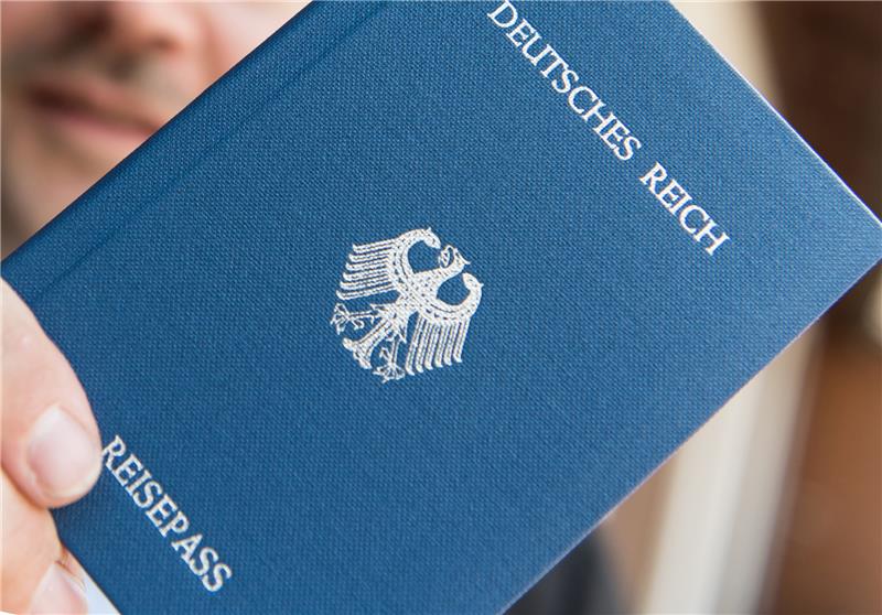 Ein Mann hält ein Heft mit dem Aufdruck „Deutsches Reich Reisepass“ in der Hand. Der Deutsche Hotel- und Gaststättenverband (Dehoga) gibt seinen Mitgliedsbetrieben Tipps zum Umgang mit sogenannten Reichsbürgern oder Neonazis. Foto: Patrick Seeger/dpa