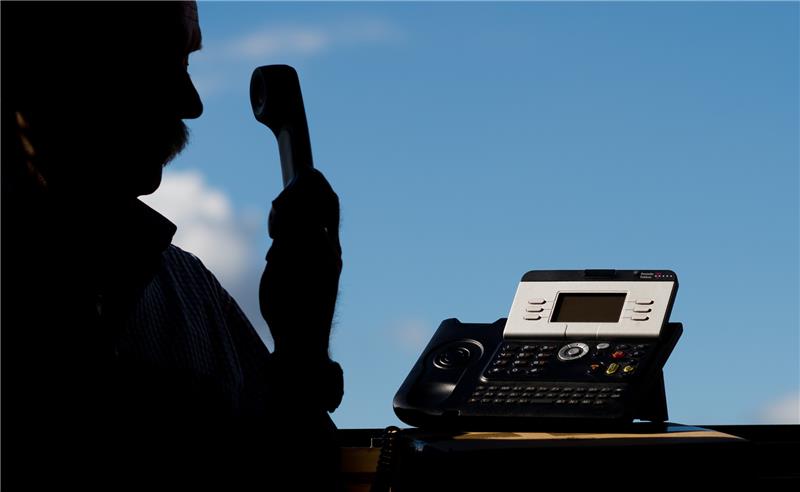 Ein Mann hält einen Telefonhörer in der Hand. Foto: Julian Stratenschulte/dpa