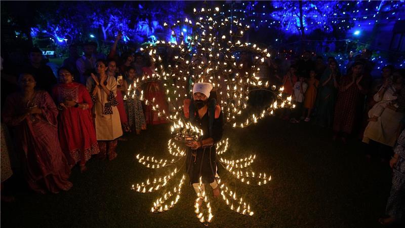 Bilder des Tages Ein Mann hält in einem mit Öllampen geschmückten Kostüm in der fünften Nacht von Navratri, dem Fest der neun Nächte, das Aarti-Ritual ab.