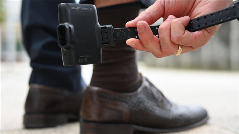 Fußfessel für Gewalttäter: Erfolg für Birgit Butter und die CDU Ein Mann hält zu Demonstrationszwecken eine elektronische Aufenthaltsüberwachung, bekannt als elektronische Fußfessel.