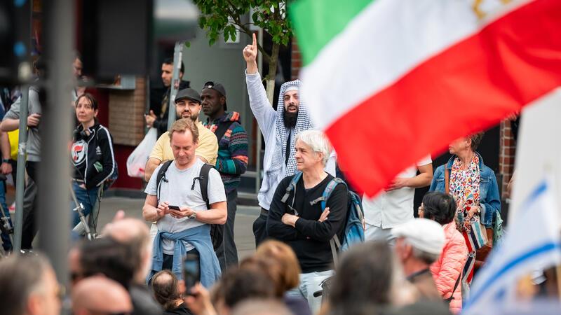 Ein Mann hebt seinen Finger (islamisches Symbol für die Einheit Gottes, sogenannter Tauhid-Finger) als Provokation am Rande der Demonstration auf dem Steindamm gegen Islamismus und Antisemitismus und für freiheitliche Werte und das Grundgesetz.