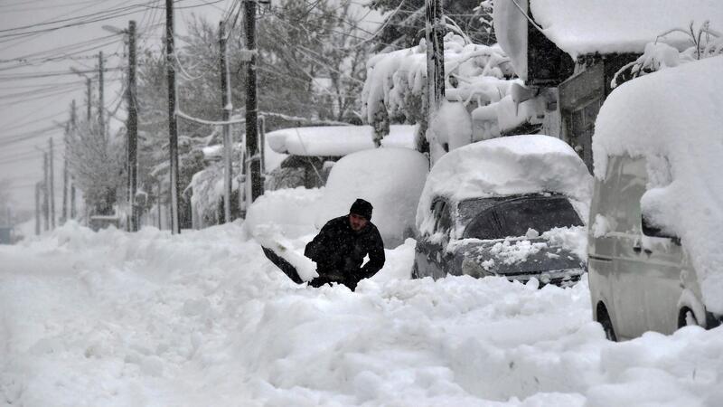 1000 Orte nach Wintereinbruch in Bulgarien ohne Strom Ein Mann in Isperich schaufelt Schnee, um sein Auto zu befreien.