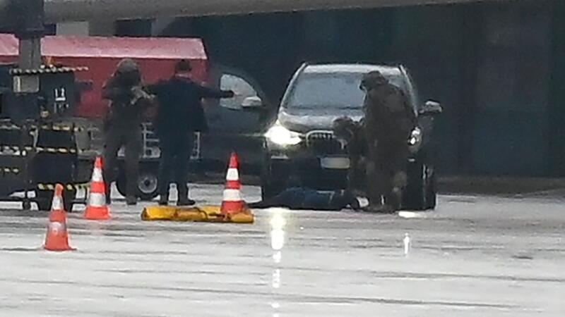 Hamburger Flughafen: Glückliches Ende einer Geiselnahme Ein Mann liegt am Hamburger Flughafen umringt von Polizeikräften auf dem Boden.