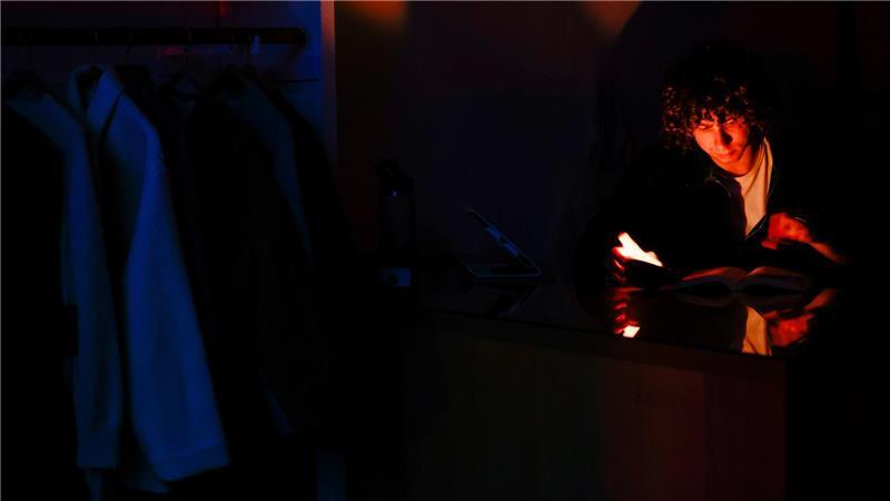 Ein Mann liest während des Stromausfalls in San Francisco bei Kerzenlicht.