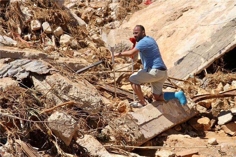 Dramatischer Anstieg der Zahl der Toten in Libyen befürchtet Ein Mann mit Krücken versucht, über Trümmer zu steigen.