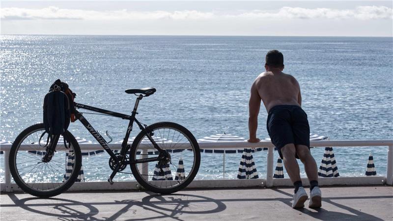 Männer oben ohne: sexy oder sexistisch? Ein Mann mit nacktem Oberkörper macht am Strand von Nizza neben seinem Fahrrad Übungen. (Archivbild)