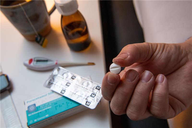 Ein Mann nimmt eine Paracetamol-Tablette ein. Foto: Foto: Lino Mirgeler/dpa