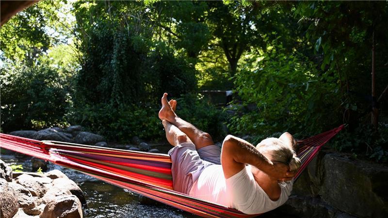 Vorläufiger Spitzenwert: In Andernach war es am heißesten Ein Mann schaukelt im Berliner in einer Hängematte über dem Wasser.
