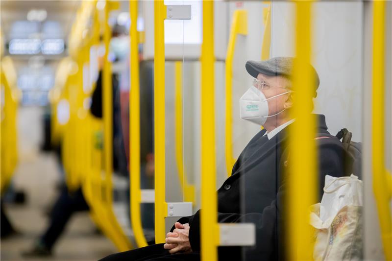 Ein Mann sitzt mit FFP2-Maske in der U-Bahn. Foto: Christoph Soeder/dpa