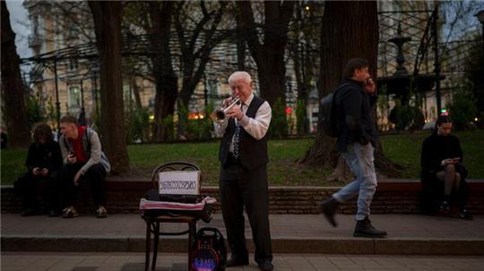 Ein Mann spielt Trompete in einem Park in Kiew, Ukraine.