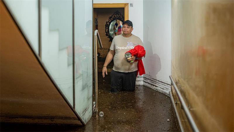 Mindestens drei Tote bei schweren Unwettern in Spanien Ein Mann steht im Treppenhaus eines Gebäudes in der an Barcelona grenzenden Stadt L’Hospitalet de Llobregat in mehr als knietiefem Wasser.