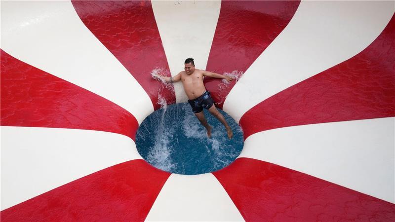 Ein Mann stürzt eine Wasserrutsche in einem öffentlichen Schwimmbad im Stadtteil Puente Piedra außerhalb von Lima hinunter.