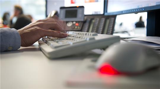 Ein Mann tippt einem Büro auf einer Tastatur. Foto: Daniel Naupold/dpa