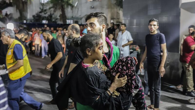 Wut in Nahost über Explosion bei Gaza-Klinik Ein Mann trägt nach dem Raketeneinschlag ein verletztes Mädchen.