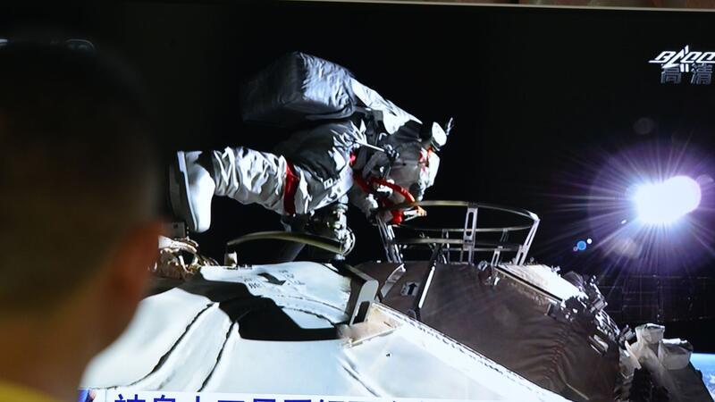Drei chinesische Astronauten sicher aus All zurück Ein Mann verfolgt vor dem Fernseher die Live-Übertragung eines Außeneinsatzes an der Raumstation „Tiangong“ (Archivbild).