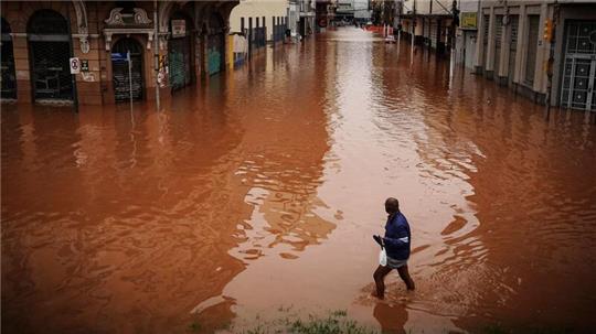 Ein Mann watet in Porto Alegre im brasilianischen Bundesstaat Rio Grande do Sul durch ein von schweren Regenfällen überschwemmtes Gebiet.