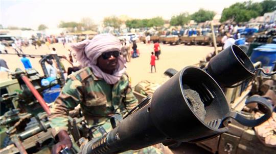 Ein Milizionär mit militärischer Ausrüstung, die angeblich während eines Gefechts im umkämpften Gebiet in Süd-Darfur erbeutet wurde (Archivbild).