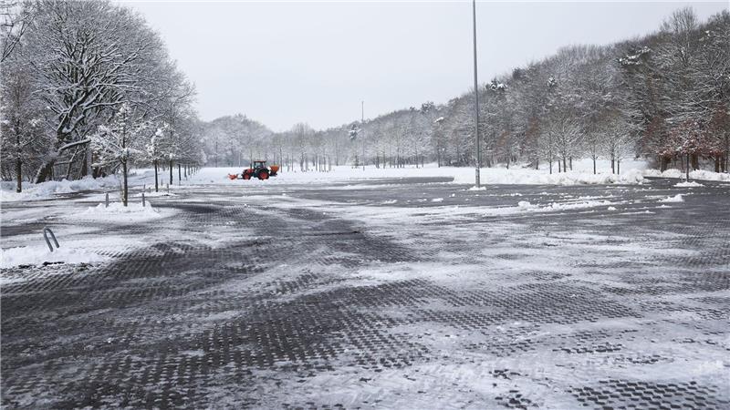 Ein Mitarbeiter befreit nahe der Barclays Arena einen Teil eines Parkplatzes vom Schnee.