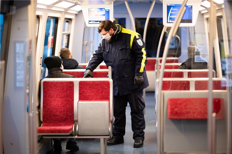 Ein Mitarbeiter der Hochbahn-Wache kontrolliertin Hamburg Fahrkarten und die Einhaltung der Maskenpflicht. Foto: Daniel Reinhardt/dpa