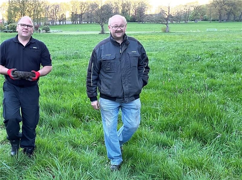 Ein Mitarbeiter des Kampfmittelräumdienstes trägt die Granate, Sondengänger Frank Hoferichter hatte ihm den Fundort gezeigt.