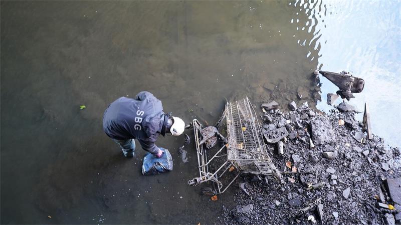 Ein Mitarbeiter des Landesbetriebs Straßen, Brücken und Gewässer reinigt den fast wasserleeren Alsterfleet. (Archivbild)