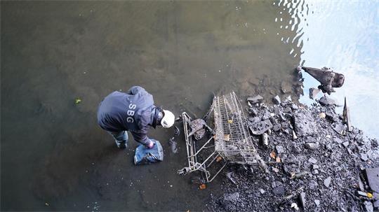 Ein Mitarbeiter des Landesbetriebs Straßen, Brücken und Gewässer reinigt den fast wasserleeren Alsterfleet. (Archivbild)