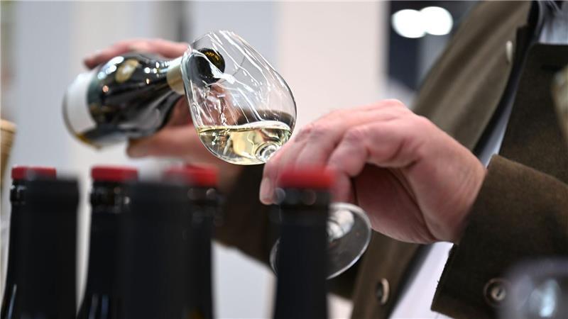 Ein Mitarbeiter des badischen Weinguts Bimmerle gießt am Prowein-Messe-Stand seiner Firma Riesling in ein Glas.