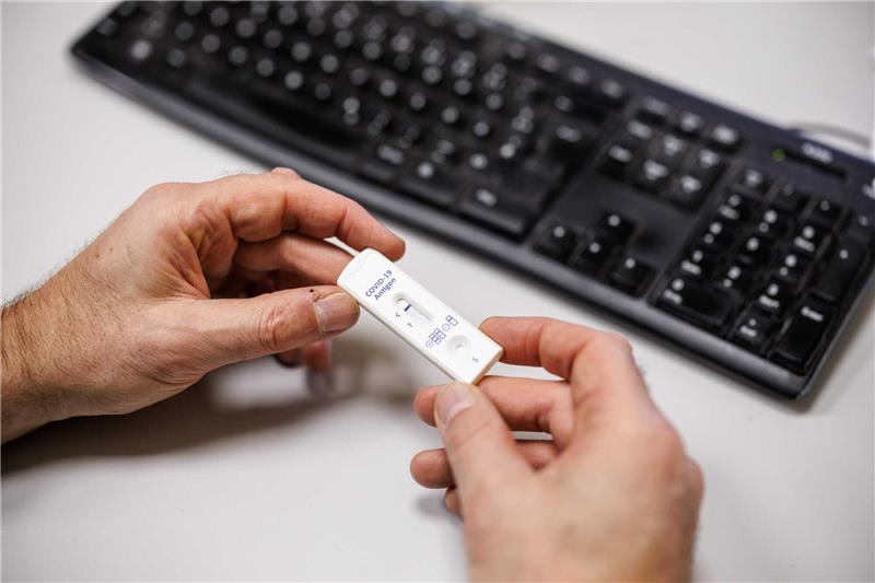 Maskenpflicht und Tests: Diese Regeln gelten ab nächster Woche bei der Arbeit Ein Mitarbeiter eines Unternehmens blickt auf das Testergebnis für einen Corona-Schnelltest. Foto: Matthias Balk/dpa