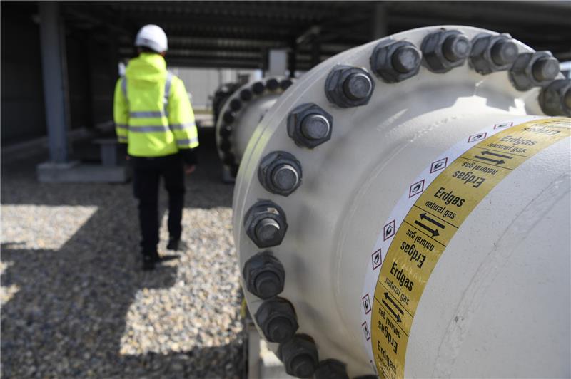 Ein Mitarbeiter geht an einem Teil einer Erdgasleitung am Gelände der Gas Connect Austria Verdichterstation. Foto: Harald Schneider/APA/dpa