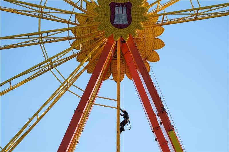 Winterdom findet ohne Abstand und Masken statt Ein Mitarbeiter klettert während der Aufbauarbeiten im Riesenrad auf dem Heiligengeistfeld. Am 5. November startet der Hamburger Winterdom unter 2-G-Bedingungen auf dem Heiligengeistfeld. Foto: Brandt/dpa