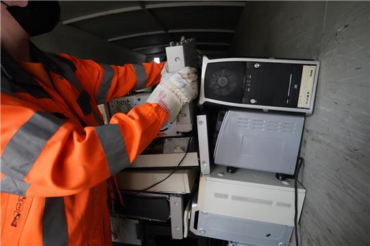 Ein Mitarbeiter legt ein Elektrogerät auf dem Recyclinghof Rondenbarg in einen Container für Elektrogeräte. Die Recyclinghöfe sollen digitaler werden. Die Menschen in Hamburg sollen in Zukunft per App und im Internet sehen können, wie lang die Schlangen vor den zwölf Recyclinghöfen der Stadt sind. Wann die digitale Lösung bereitsteht, ist aber noch nicht klar. Foto: Marcus Brandt/dpa