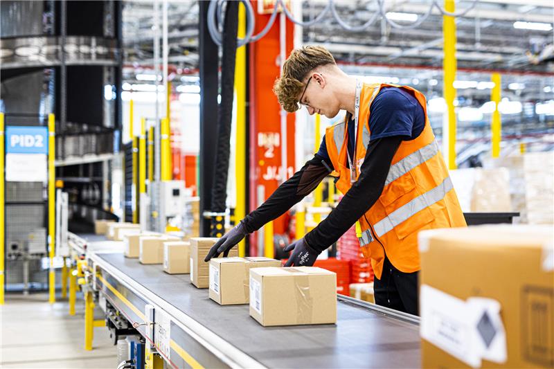 Streikaufruf bei Amazon mitten im Geschenke-Endspurt Ein Mitarbeiter legt im neuen Logistikzentrum des Onlineversandhändlers Amazon in Helmstedt ein Paket auf ein Fließband. Foto: Moritz Frankenberg/dpa