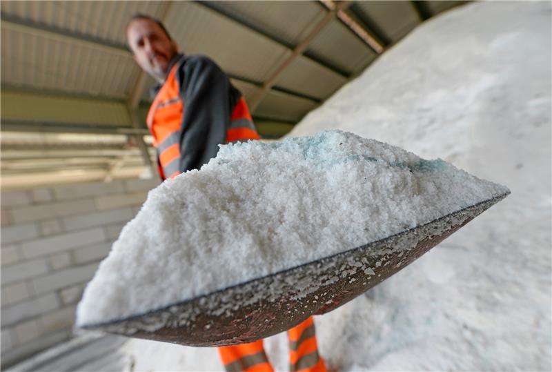 Ein Mitarbeiter schippt Salz für den Einsatz im Winterdienst. In Stade soll eine neue Halle für Streugut entstehen. Symbolbild: Uwe Zucchi /dpa