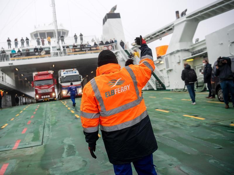 Ein Mitarbeiter von Elbferry steht auf der Fähre «Greenferry I» und kontrolliert die Abfahrt der Autos. Foto: Sina Schuldt/dpa