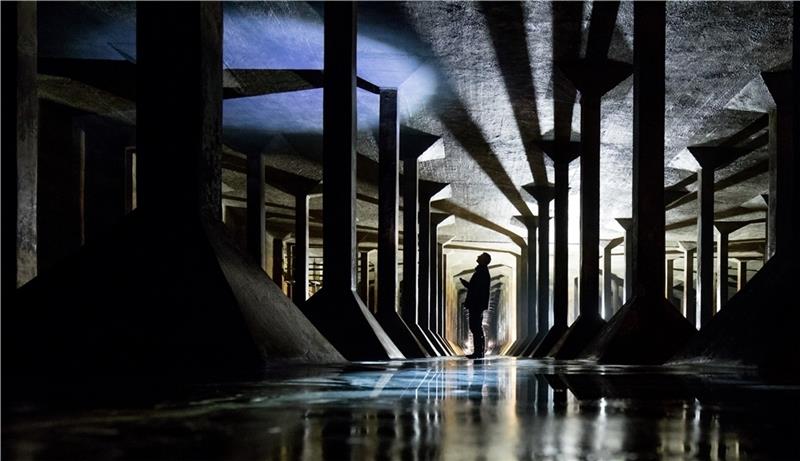 Ein Mitarbeiter von Hamburg Wasser leuchtet mit einer Taschenlampe an die Decke in einem unterirdischen Trinkwasserbehälter . Der rund 20 000 Kubikmeter fassende Betonspeicher im Stadtteil Rothenburgsort wird bis Ende des Monats auf Schäden