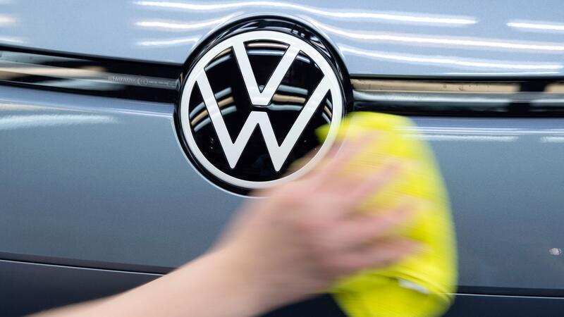 Emden: Bauernproteste bringen Produktion bei VW zum Erliegen Ein Mitarbeiter von Volkswagen streicht mit einem Tuch über ein Fahrzeug von VW.
