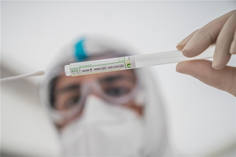 Omikron: Landkreis baut Impfangebot und Corona-Hotline aus Ein Mitglied des medizinischen Personals in einem Corona-Testzentrum steckt ein Wattestäbchen nach einem PCR-Abstrich zum Test auf Covid-19 in ein Röhrchen (Symbolbild). Foto: Michael Kappeler/dpa