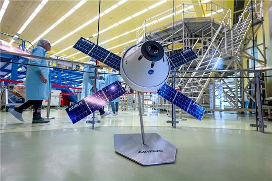 Ein Modell vom Europäische Servicemodul (ESM) steht vor dem ESM-5, an dem Arbeiten stattfinden. Airbus informiert im Bremer Werk über die Zukunft der Monderkundung. Ein wichtiges Teil des Raumschiffs Orion, das sogenannte Europäische Servicemodul (ESM), wird in Bremen gebaut. Foto: Sina Schuldt/dpa