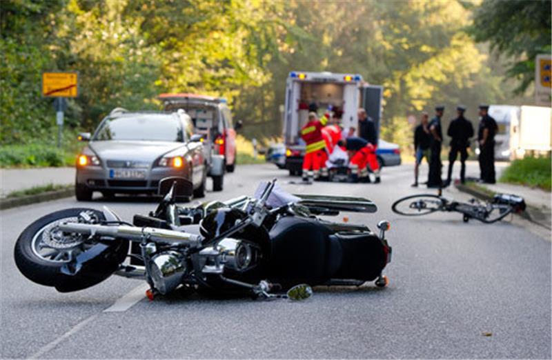 Ein Motorrad und ein Fahrrad liegen am 18. September 2014 in Hamburg nach einem Unfall auf der Straße. Bei dem Zusammenstoß im Stadtteil Lohbrügge wurden zwei Menschen verletzt. Foto: Daniel Bockwoldt/dpa