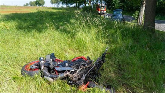 Ein Motorrad liegt auf einer Wiese neben der Straße.