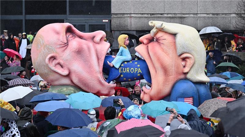 Ein Mottowagen mit Putin und Trump, die versuchen Europa zu fressen, fährt an den Zuschauern beim Rosenmontagszug in Düsseldorf vorbei. 