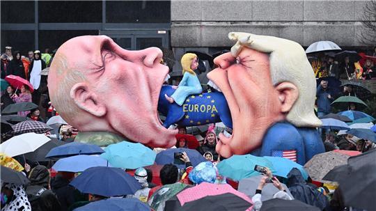 Ein Mottowagen mit Putin und Trump, die versuchen Europa zu fressen, fährt an den Zuschauern beim Rosenmontagszug in Düsseldorf vorbei. 