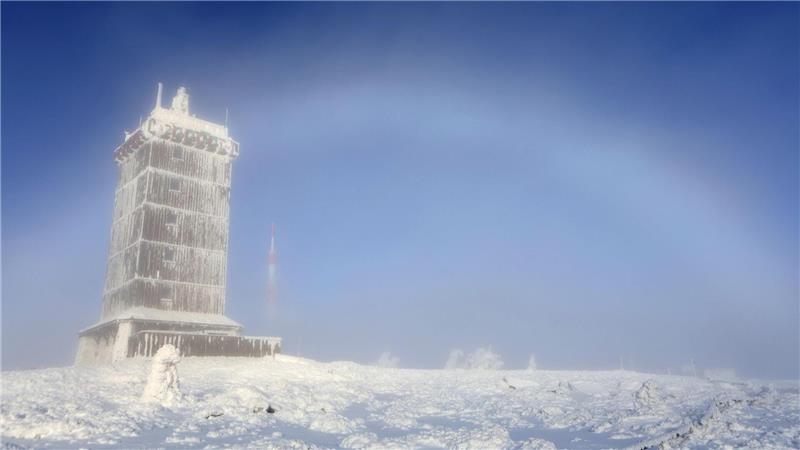 Ein Nebelbogen bildet sich hinter der Wetterwarte auf dem Brocken. 