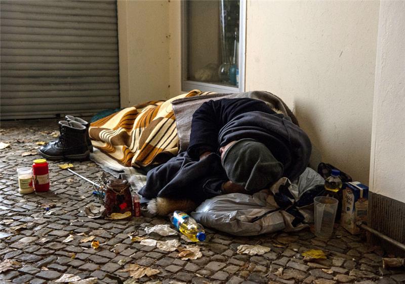 Ein Obdachloser liegt in einem Hauseingang. Obdachlosen in Berlin stehen wieder Angebote der Kältehilfe offen. (zu "Gegen das Erfrieren auf der Straße - Kältehilfe startet in 30. Saison") Foto: Paul Zinken/dpa