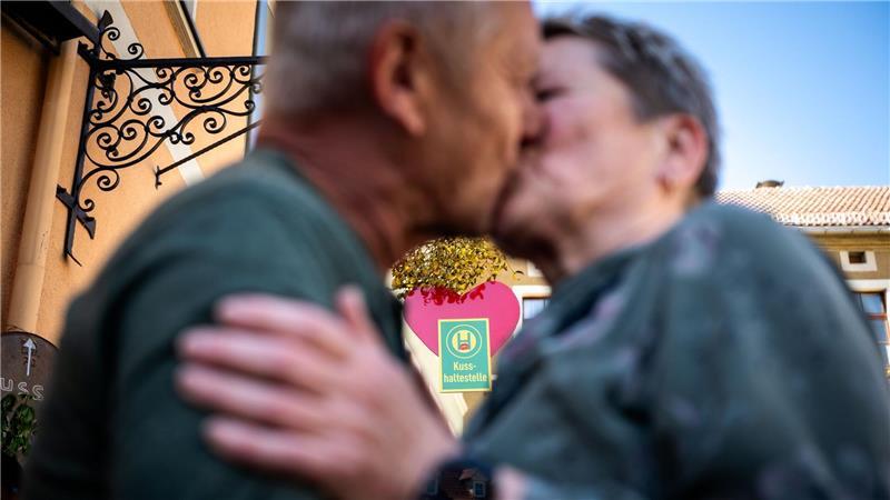 Ein Paar küsst sich an der Eisenberger „Kusshaltestelle“. 