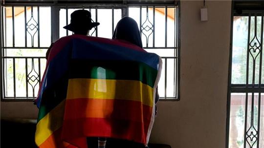 Ein Paar mit einer Pride-Fahne: Die rechtliche Situation offen queerer Menschen ist nicht nur in Uganda schwierig.