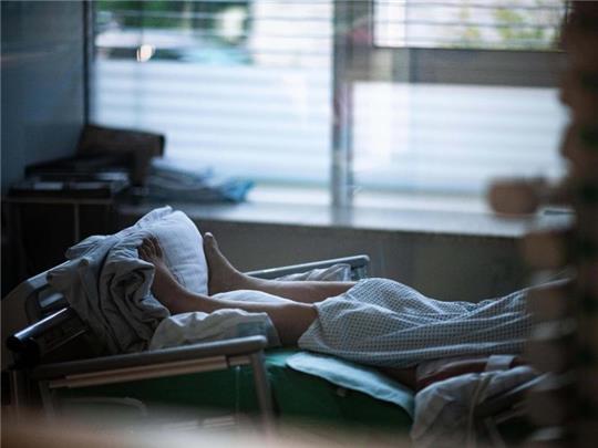 Ein Patient liegt in einem Zimmer auf einer Corona-Intensivstation. Foto: Fabian Strauch/dpa/Archivbild