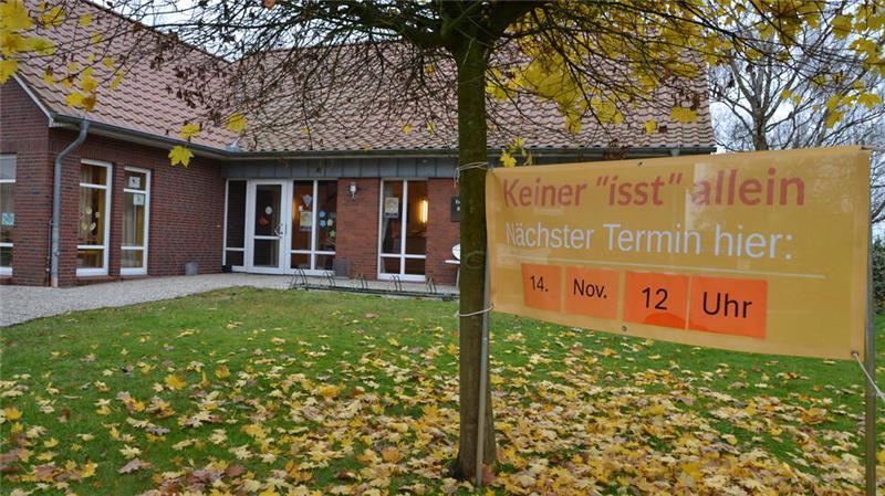 Ein Plakat am Gemeindehaus lädt zum gemeinsamen Essen ein.